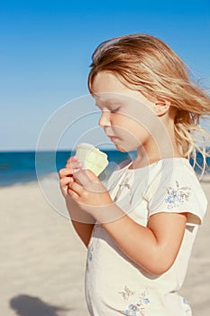 happy child on the beach near the swimming pool outdoors eating ice cream in summer park