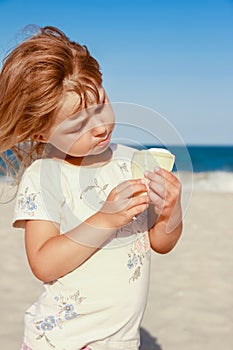 happy child on the beach near the swimming pool outdoors eating ice cream in summer park