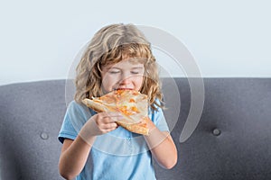 Happy child biting off big slice fresh made pizza. Little boy eating pizza. Cute little boy eats pizzas. Happy handsome