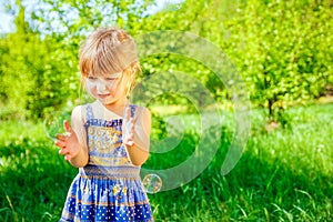 Happy child blowing bubbles on nature in pairs