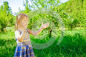 Happy child blowing bubbles on nature in pairs