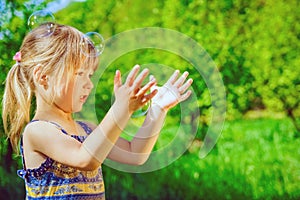 Happy child blowing bubbles on nature in pairs