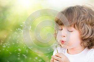 Happy child blowing dandelion