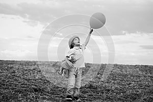 Happy child boy with balloons jumping outdoor against blue sky background. Freedom for kids. Freedom concept. Faith and