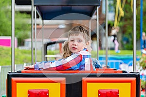 Happy child boy having fun in park. Taking a ride on baby train