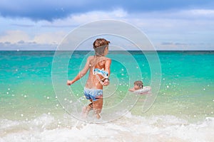 Happy child boy having fun in water, summer vacations on t