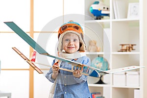 Happy child boy with model of airplane dreams of becoming pilot