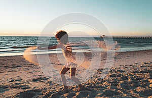 Happy child boy playing in the sea. Kid having fun outdoors. Summer vacation and healthy lifestyle concept. Kids play