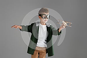 Happy child boy playing with wooden toy airplane. dream
