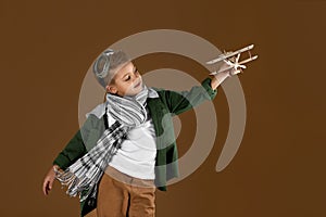 Happy child boy playing with wooden toy airplane. dream