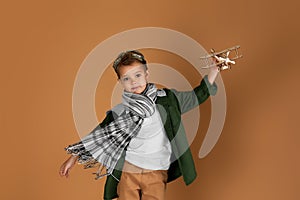 Happy child boy playing with wooden toy airplane. dream