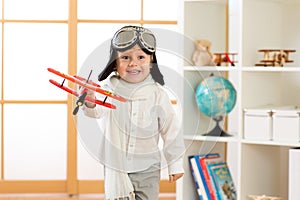 Happy child boy plays with toy airplane and dreams of becoming pilot