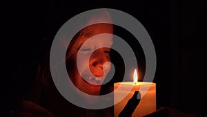 Happy child with candles, prayer girl in night, kid portrait, face in dark 4K