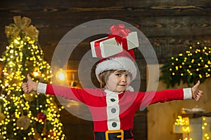 Happy child with Christmas gift box. Merry Christmas and Happy Holidays. New year concept. Funny kid holding Christmas