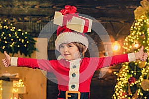Happy child with Christmas gift box. Merry Christmas and Happy Holidays. New year concept. Funny kid holding Christmas