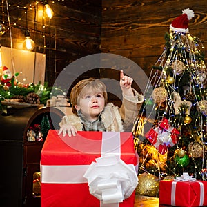 Happy child with Christmas gift. Happy kid having fun with big gift box. Christmas decorations. Wish you merry Christmas