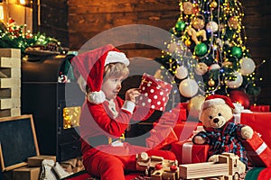 Happy child with Christmas gift. New year kids. Cheerful cute child opening a Christmas present. Christmas child holding