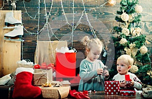 Happy child with a Christmas present on wooden background. Christmas story concept. Cute little kids celebrating