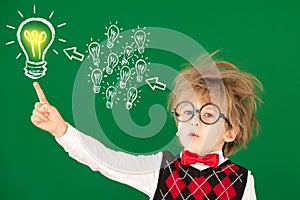 Happy child in class against green chalkboard