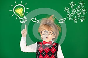 Happy child in class against green chalkboard