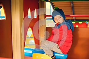 Happy child on colorful castle playground. Cute little boy playing outdoors in cold autumn time. Happy and healthy childhood. Colo