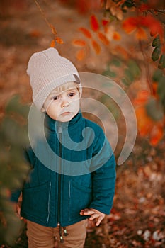 The happy child is coming. A boy dressed in a green jacket and brown trousers.