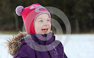 A happy child with a cute hat out in the snow