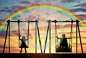 Happy child is a disabled person in a wheelchair riding an adaptive swing next to a healthy child together