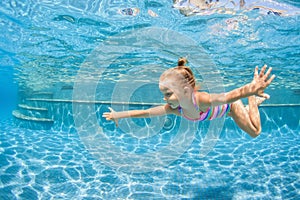 Happy child dive underwater with fun in swimming pool