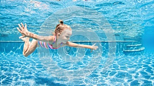 Happy child dive underwater with fun in swimming pool