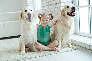 Happy child with a dog. Portrait of a girl with a pet. Labrador Retriever at home.