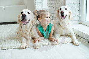 Happy child with a dog. Portrait of a girl with a pet. Labrador Retriever at home.