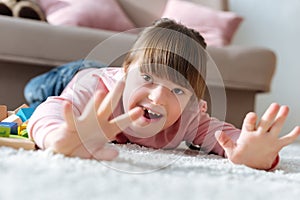 Happy child with down syndrome lying on floor