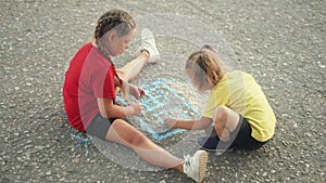 Happy child draw with chalk on asphalt in park. Child play and paint house and sun. Happy family concept Dream of home