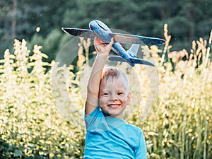 Happy child dreams of traveling and playing with an airplane