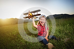 happy child dreams of traveling and playing with an airplane pilot aviator in outdoor