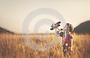 happy child dreams of traveling and playing with an airplane pilot aviator in outdoor