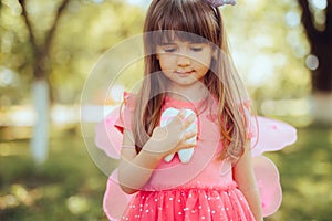 Happy Child Dressed as The Tooth Fairy Holding Molar