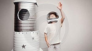 Happy child dressed in an astronaut costume playing with hand ma