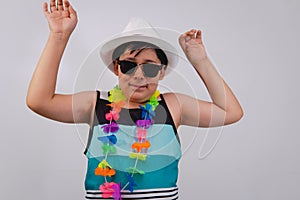 Happy child dressed in beach clothes on a white background with a flower necklace. Very animated boy on the beach with his arms