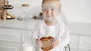 A happy child is eating. Attractive boy in the kitchen eating cookies with raisins, oatmeal cookies with pleasure. The