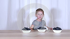 Happy child eating berries. Blueberries and blueberries. Fun. Fruits.