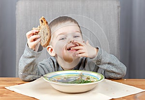 Happy child eating bread for dinner