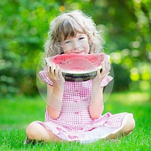 Happy child eating watermelon