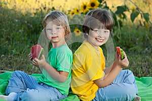 Happy child eating watermelon in garden.