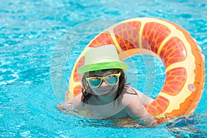 Happy child enjoying summer vacation outdoors in the water in the swimming pool.