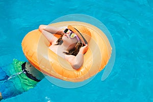 Happy child enjoying summer vacation outdoors in the water in the swimming pool.