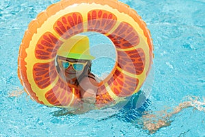 Happy child enjoying summer vacation outdoors in the water in the swimming pool.