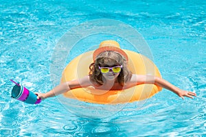 Happy child enjoying summer vacation outdoors in the water in the swimming pool.