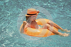 Happy child enjoying summer vacation outdoors in the water in the swimming pool.